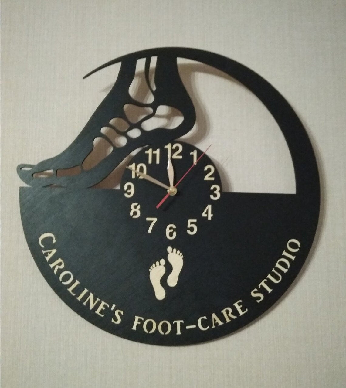 Personalized wall clock featuring a stylized foot and footprint graphics, ideal for podiatry or wellness studios