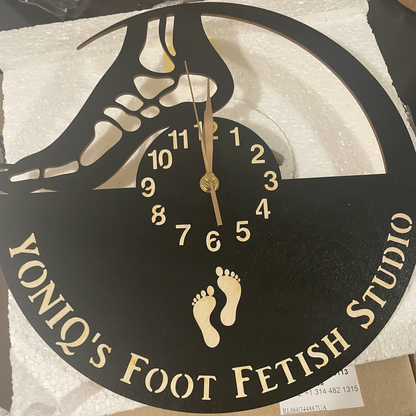 Wall clock with a foot silhouette design and custom studio name engraved on the bottom
