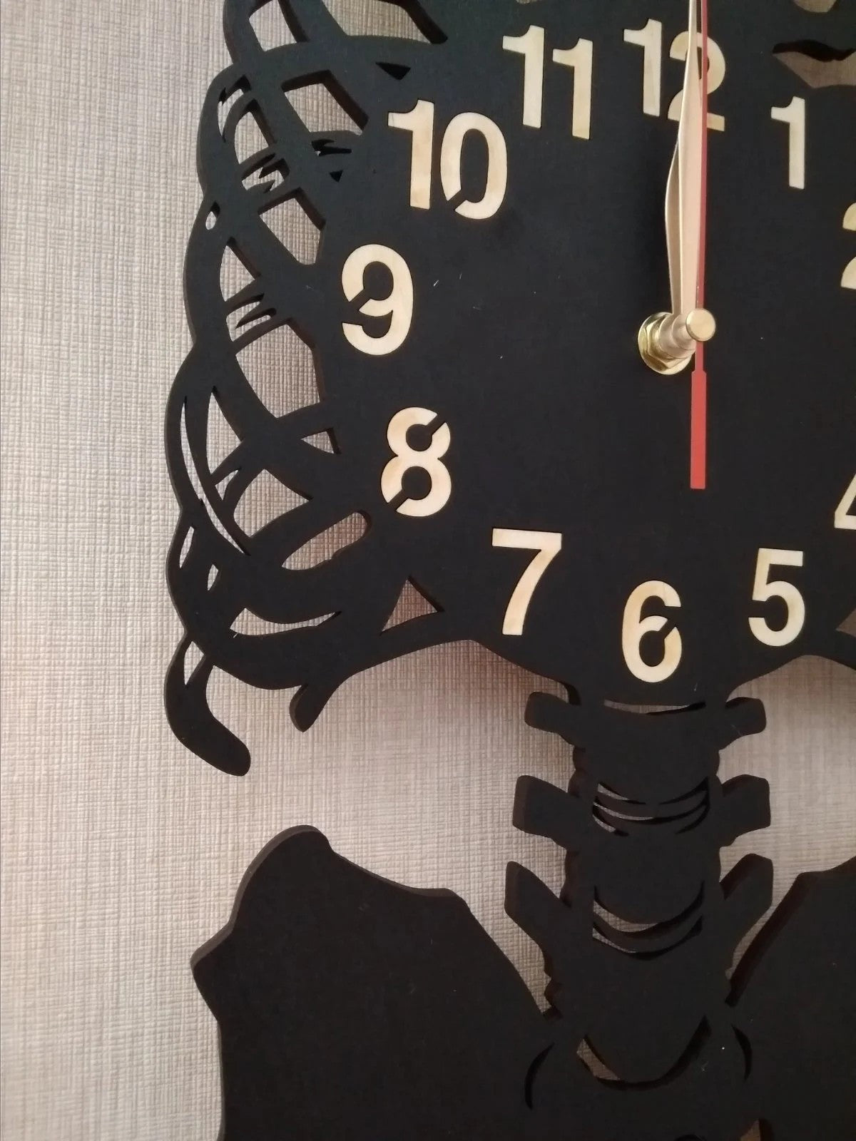 Handcrafted anatomical skeleton wall clock made from black wood with light numerals