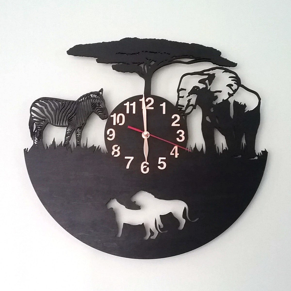 Black wall clock with African wildlife design, showing lions, zebra and elephant in profile