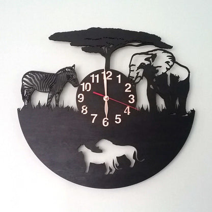 Black wall clock with African wildlife design, showing lions, zebra and elephant in profile