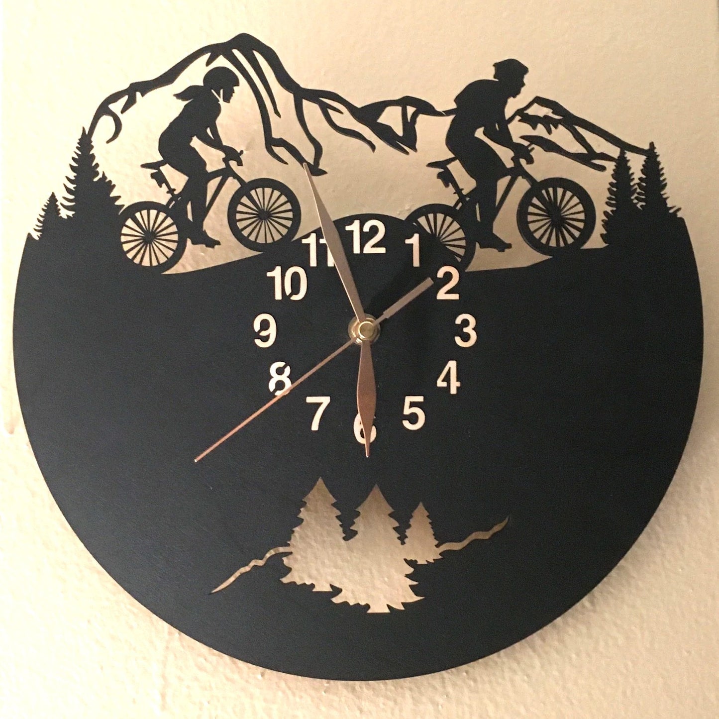 Cycling gift clock with silhouettes of man and woman riders on woodland trail