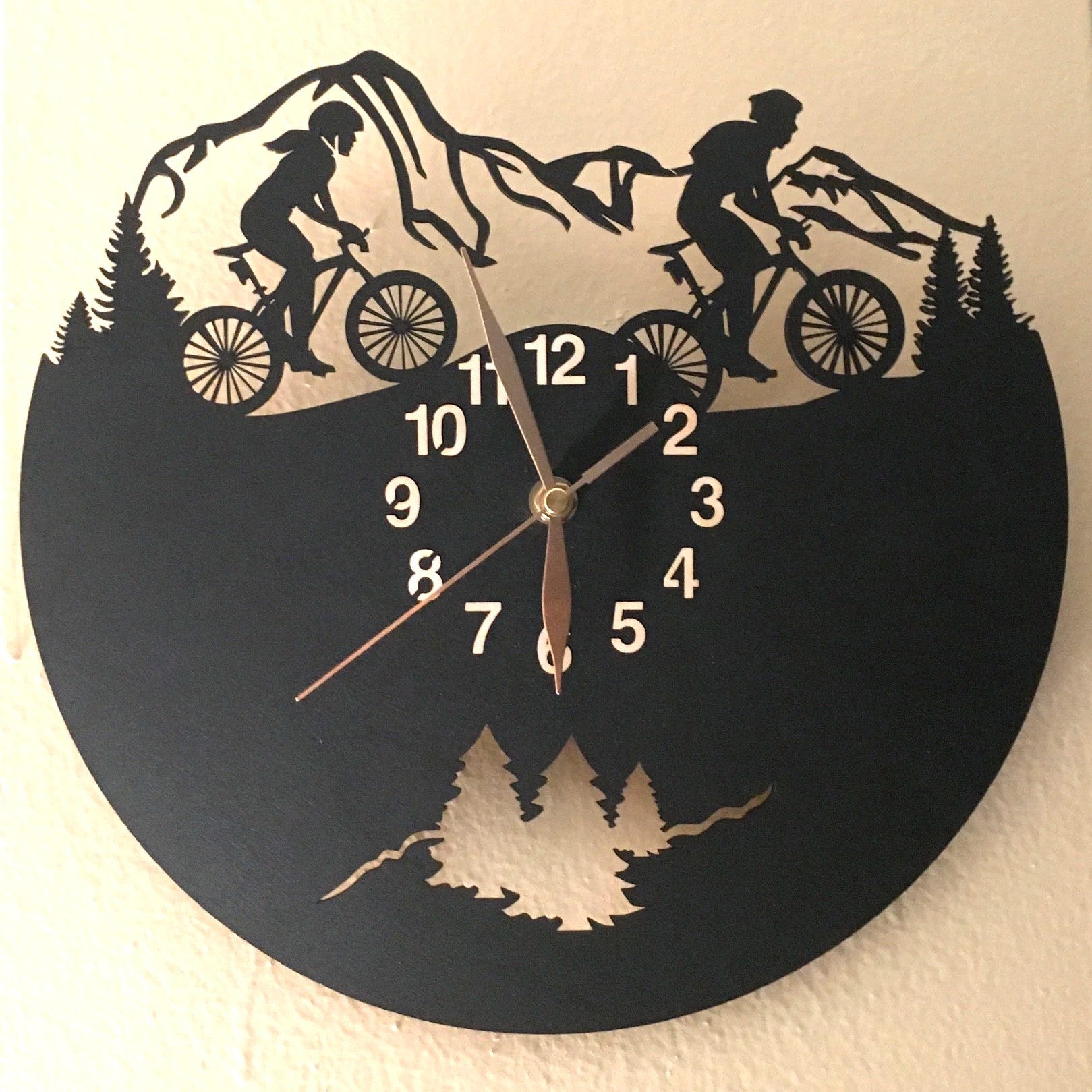 Cycling gift clock with silhouettes of man and woman riders on woodland trail