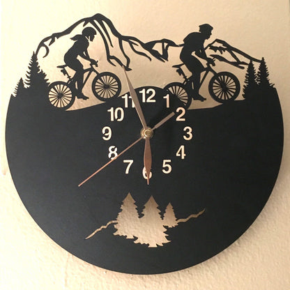 Cycling gift clock with silhouettes of man and woman riders on woodland trail