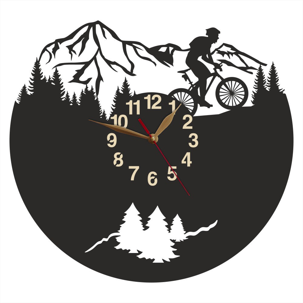 Wall clock with male cyclist silhouette riding through forest and mountains