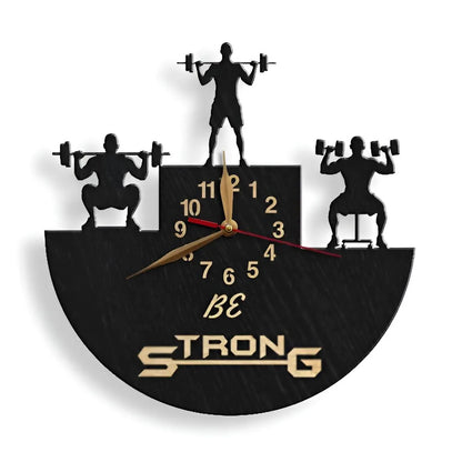 Fitness-themed clock with motivational phrase "Be Strong" and dumbbell lifters