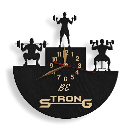 Fitness-themed clock with motivational phrase "Be Strong" and dumbbell lifters