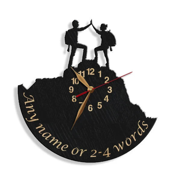 Laser-cut wooden wall clock showing a man and woman on a mountain peak, celebrating with a high-five – symbol of unity and shared goals.