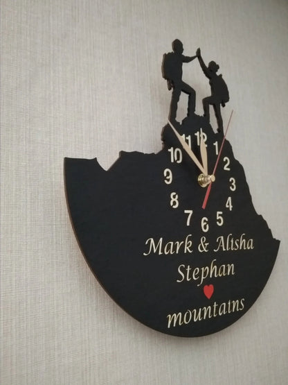 Wall clock with man and woman hikers giving a high-five on a mountain peak – personalized name engraving.