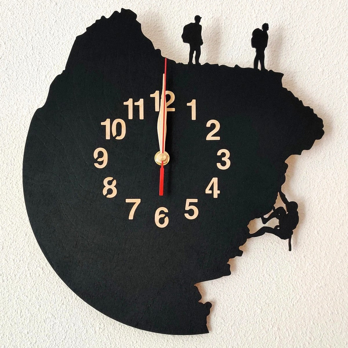 Adventure-themed wall clock showing cliff scaling scene with two hikers and a climber above