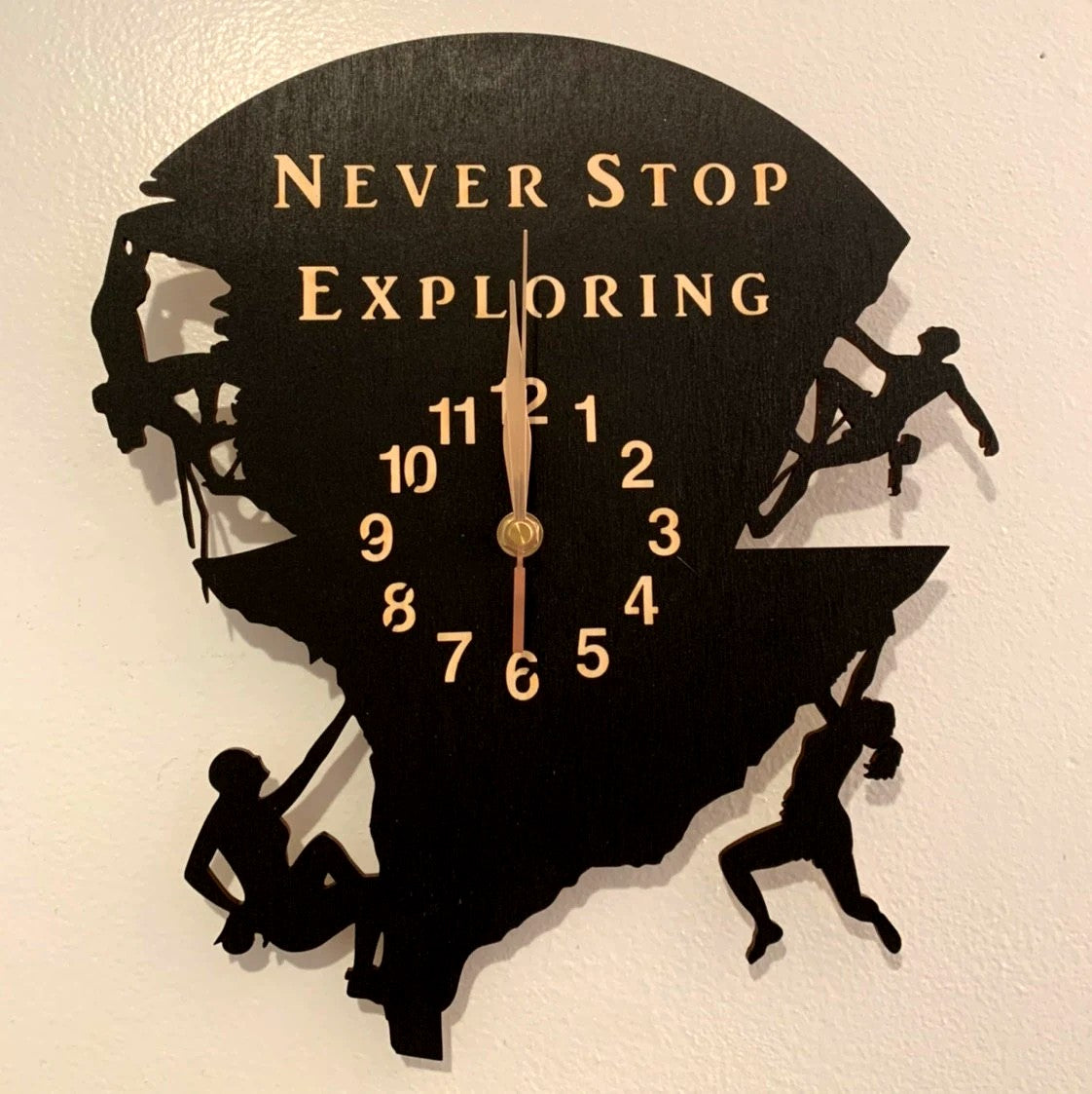 Rock climbing silhouette wall clock featuring a rope team on a cliff, engraved with “Never Stop Exploring”