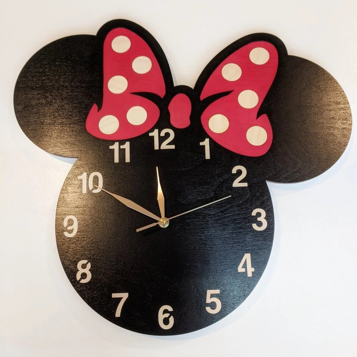 Wall clock with Minnie Mouse design featuring ears and a red polka-dot bow