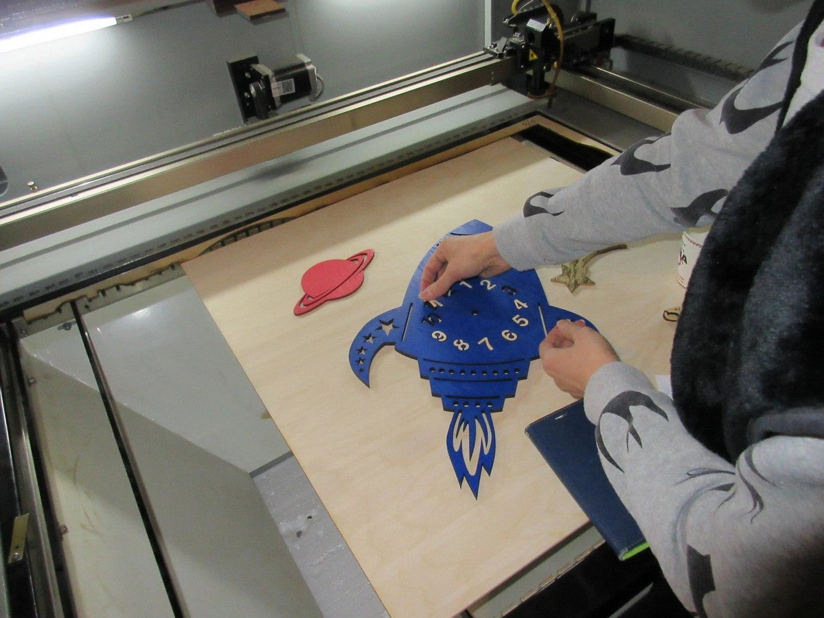 Handcrafted wooden rocket wall clock for kids room decor being assembled in our workshop