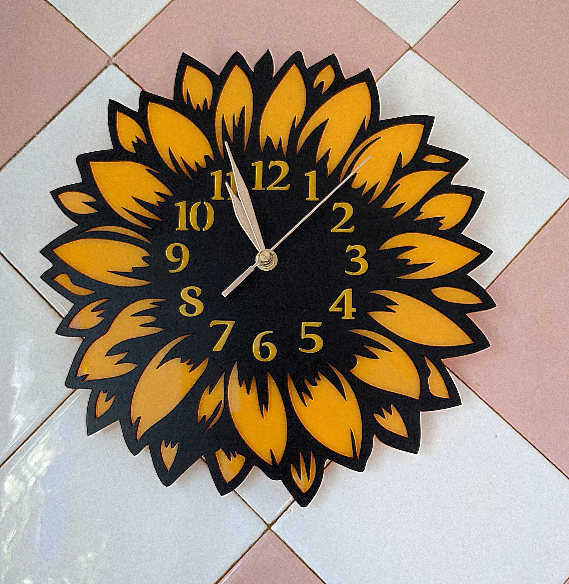 Sunflower wall clock mounted on pink and white tile background