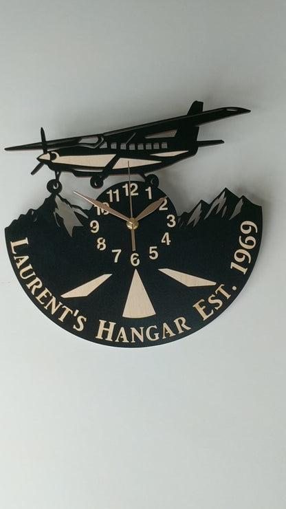 Handcrafted aviation wall clock with airplane above mountain peaks, perfect for pilots and travelers.