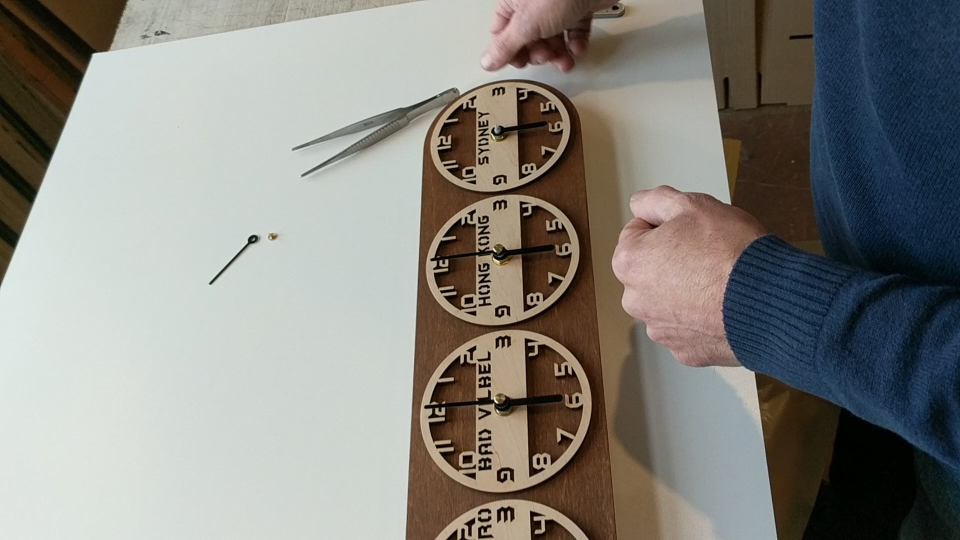 Video showing handmade wooden world time zone clocks with multiple dials, each labeled with different cities and time zones