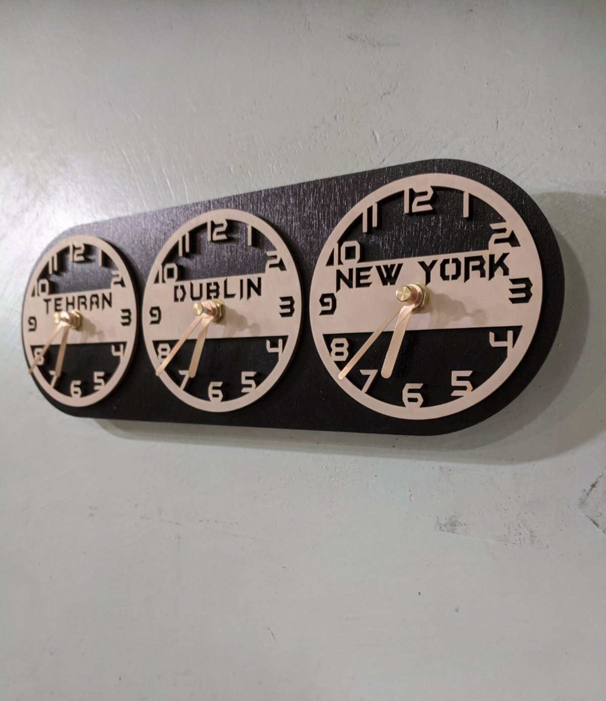 A wooden wall clock with multiple circular clock faces displaying different time zones with city names.